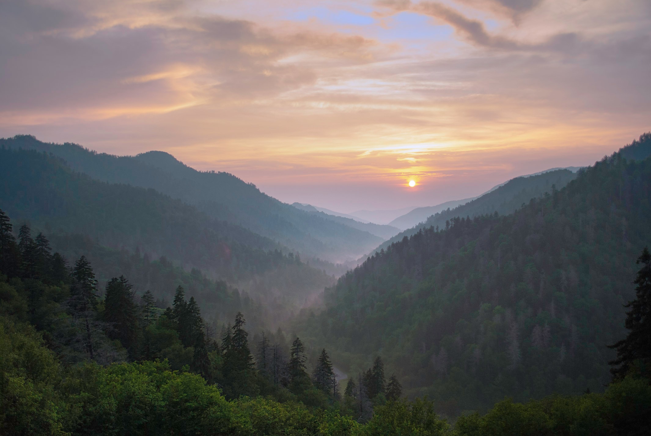 Sun setting over misty layered ridges in the Great Smoky Mountains